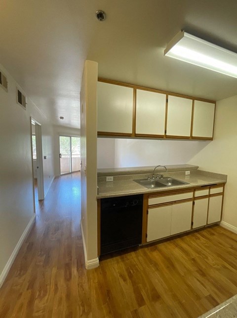 A kitchen with wooden floors and white walls.
