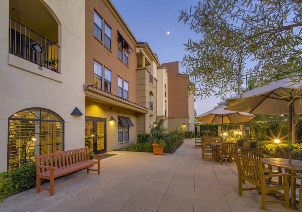a patio with benches and tables outside of a building