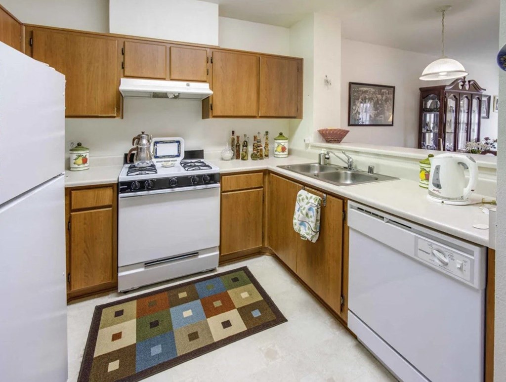 a kitchen with white appliances and wooden cabinets