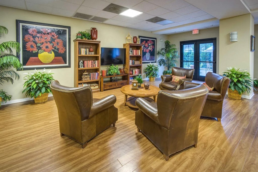 a living room with leather chairs and a tv