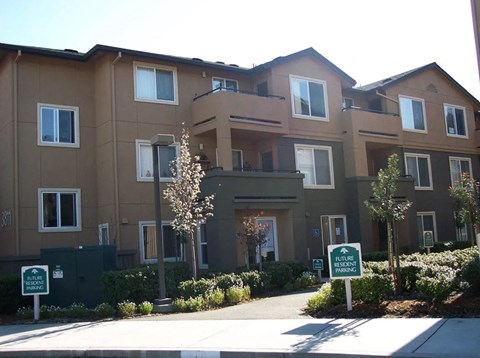 an apartment building with a sidewalk in front of it