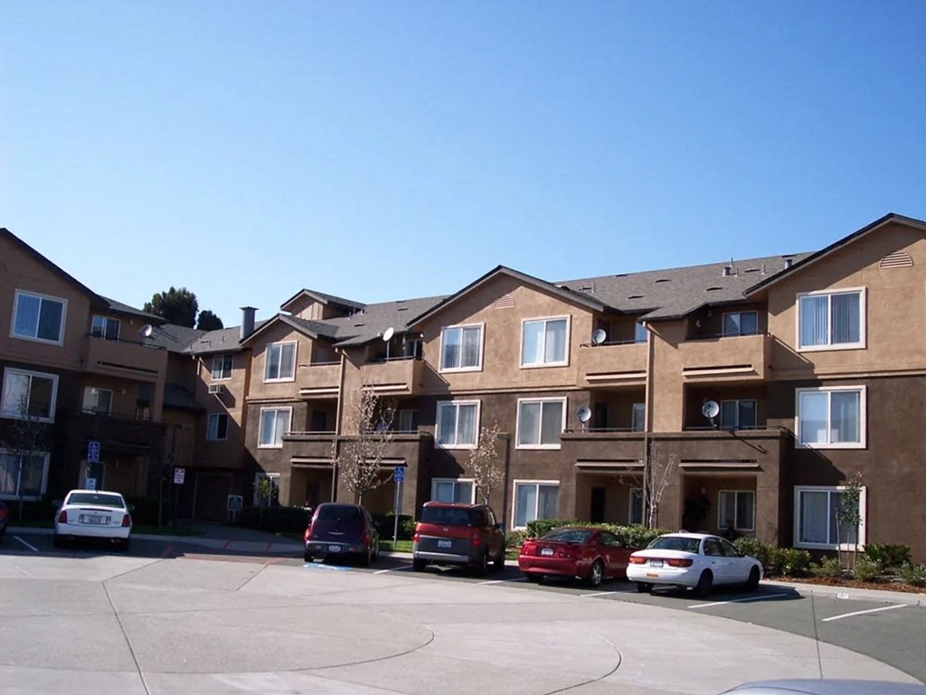 an apartment building with cars parked in front of it