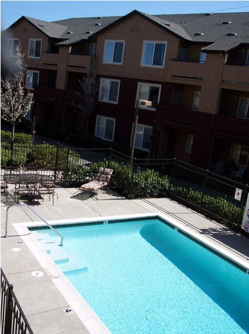 a swimming pool in front of an apartment building