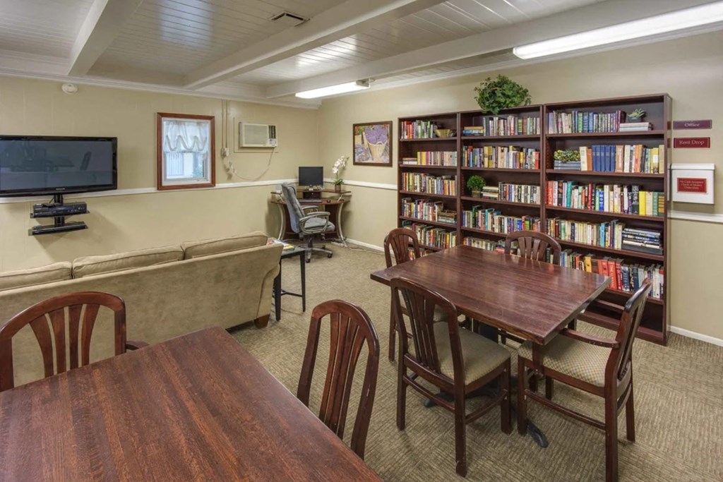 a library with a table and chairs and a couch