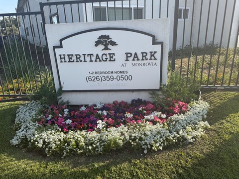 A sign for Heritage Park at Monrovia with a phone number and a tree logo.
