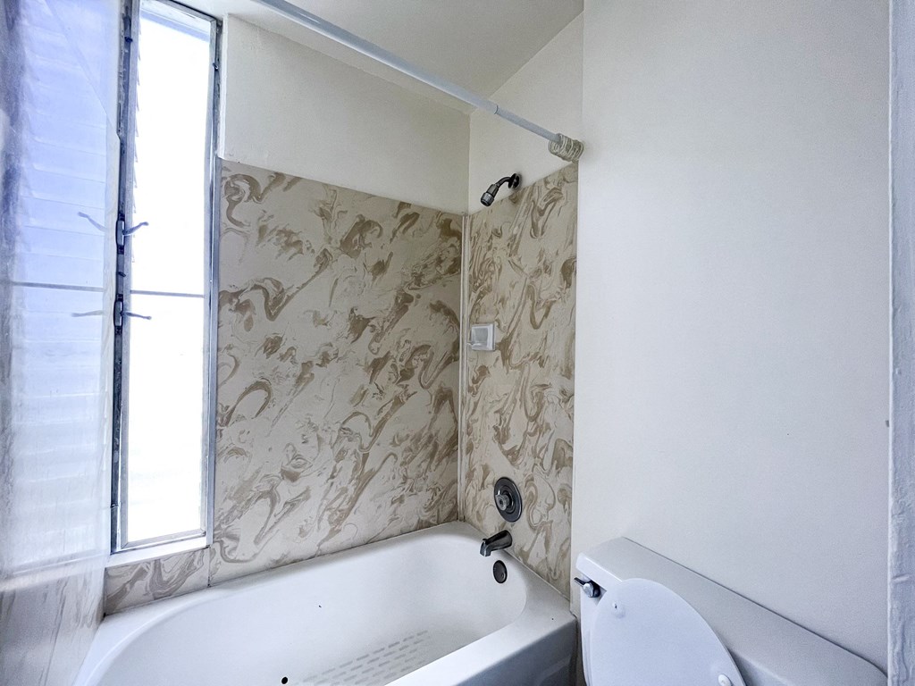 a bathroom with a bathtub and a toilet