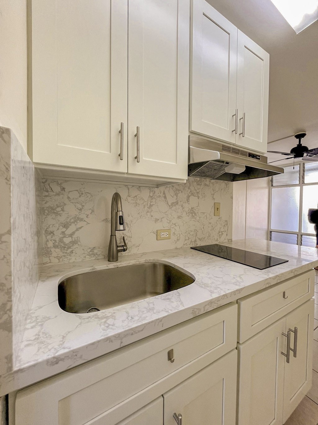 Counter Area a kitchen with white cabinets and a sink