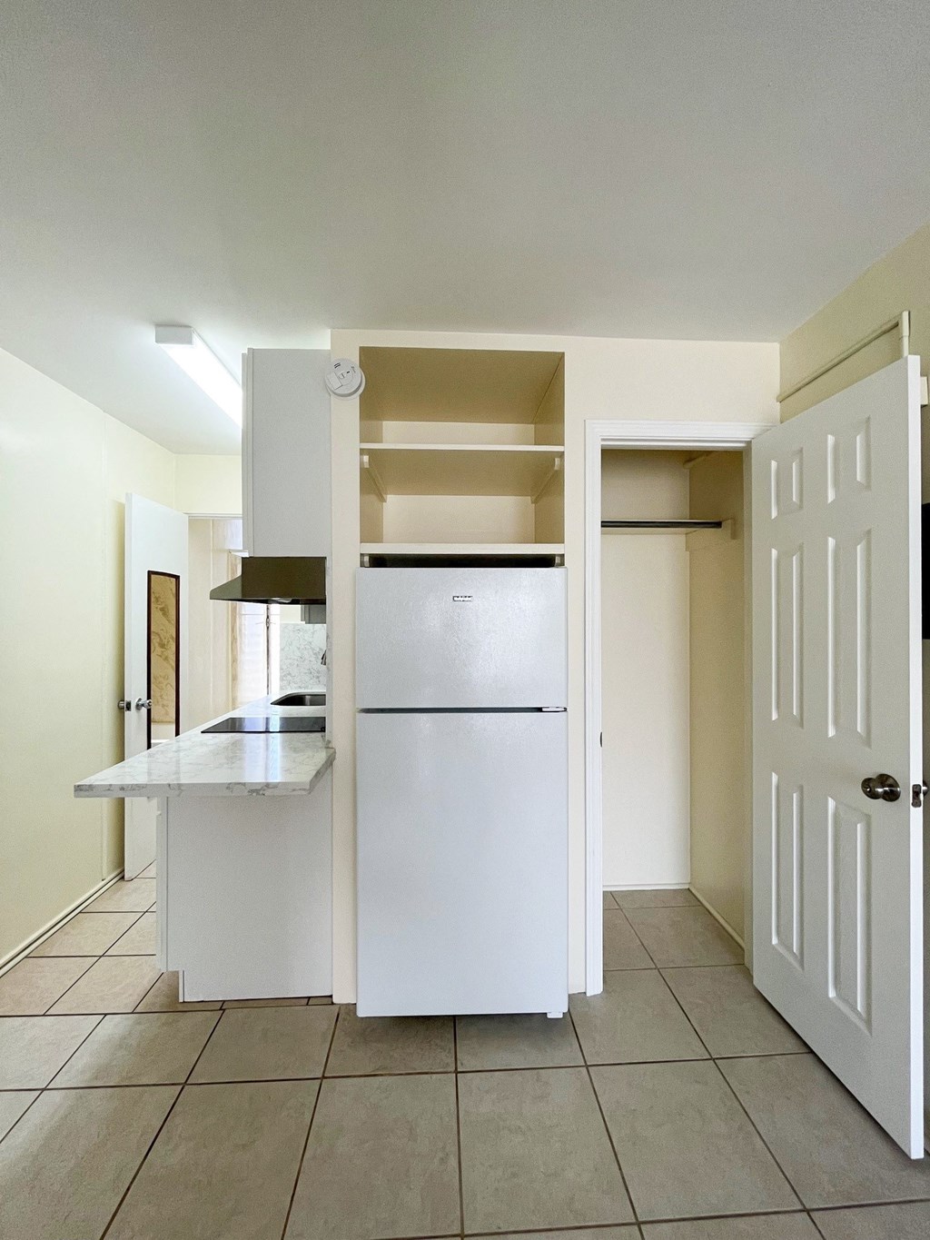 a kitchen with white cabinets and a tiled floor
