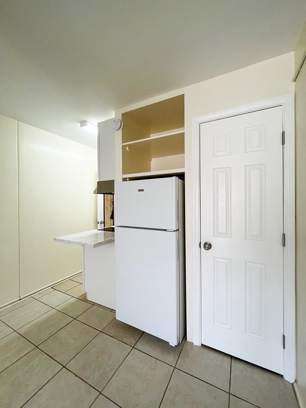 Studio Fridge and Closet a kitchen with a refrigerator and a table