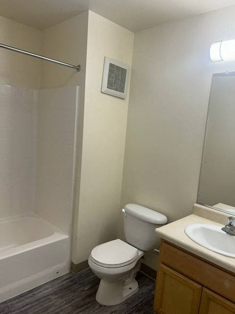 A white toilet sits next to a sink in a small bathroom.