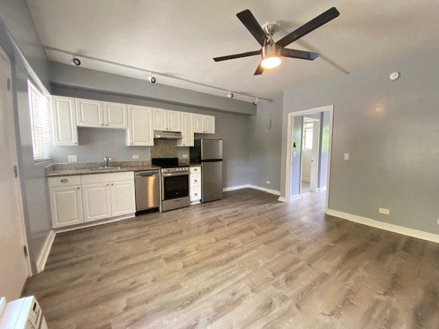 Hobron Apartments living area and kitchen area with appliances, cabinets, and counters