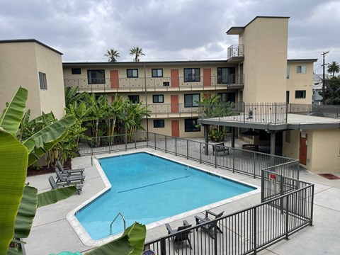 A pool in a courtyard surrounded by a fence.