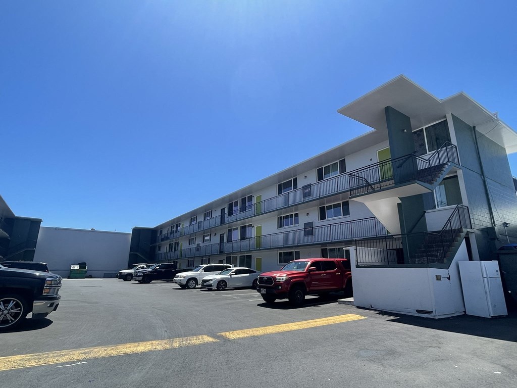a building with a parking lot and cars in front of it