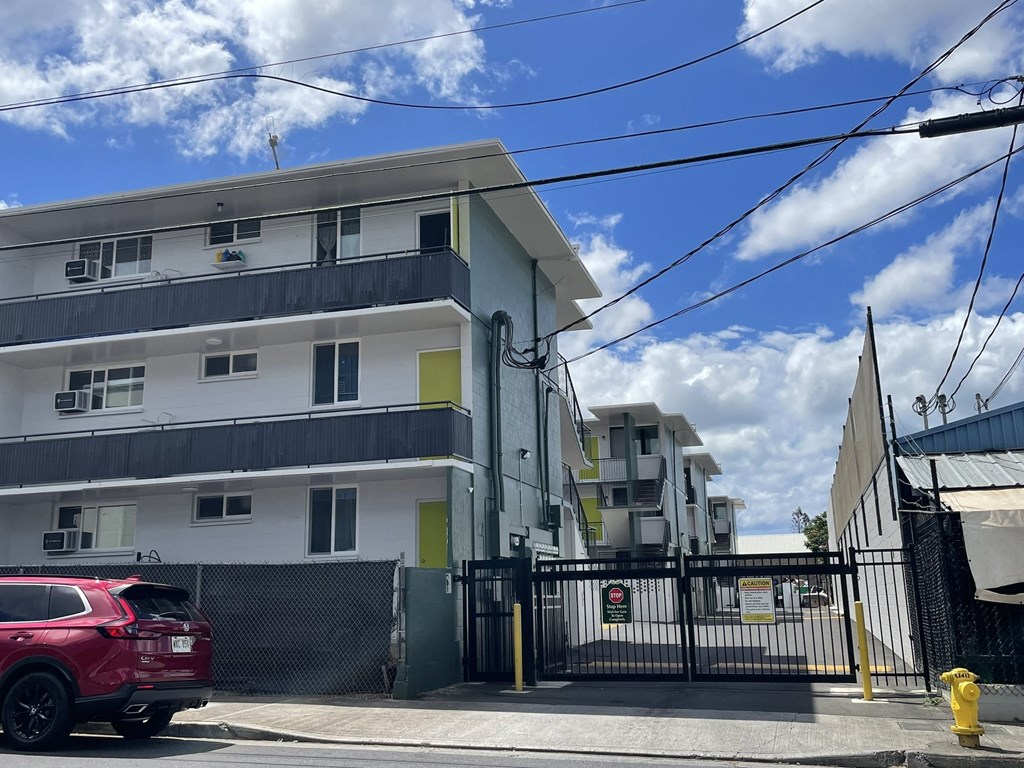 an apartment building with a red car parked in front of it
