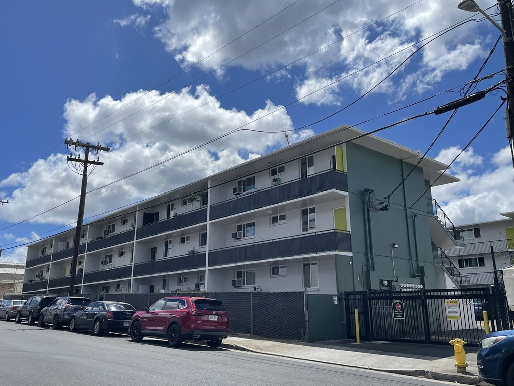 an apartment building on a city street with parked cars