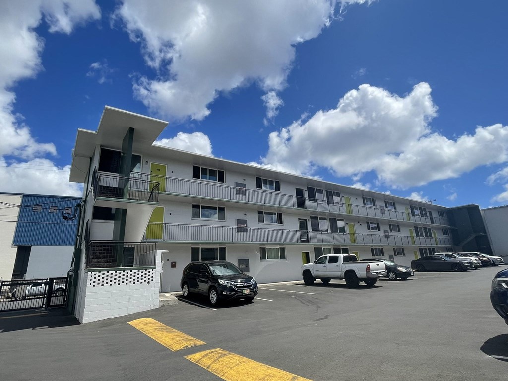 a large apartment building with cars parked in front of it