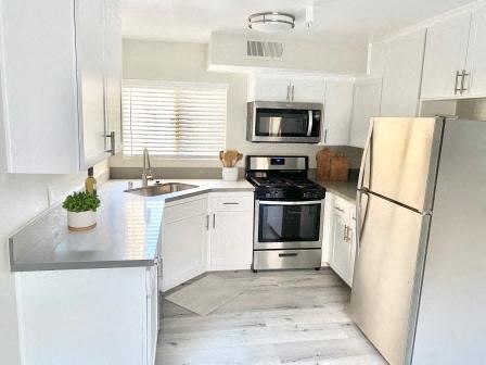 a white kitchen with a refrigerator and a stove
