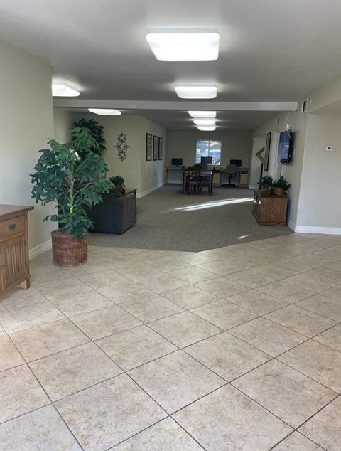 A spacious room with tiled flooring and a large window.