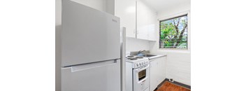A white fridge and stove in a small kitchen.