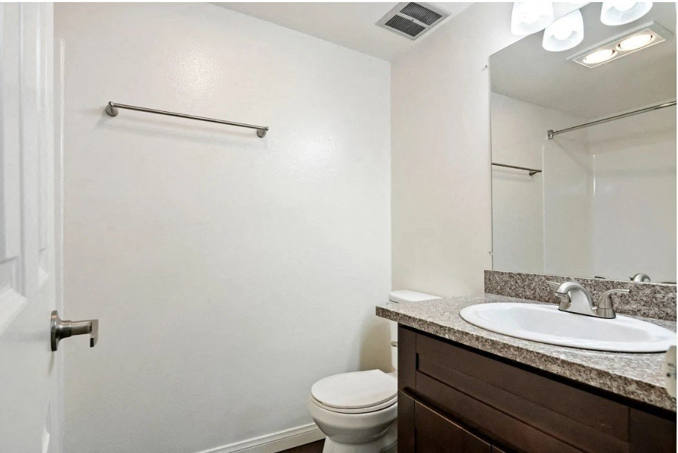 a bathroom with a sink toilet and a mirror