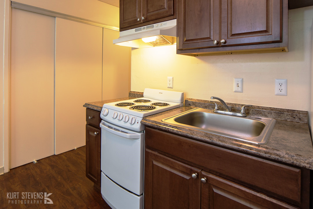 Kam IV Apartments closet storage and Kitchen area with appliances, cabinets, and counters
