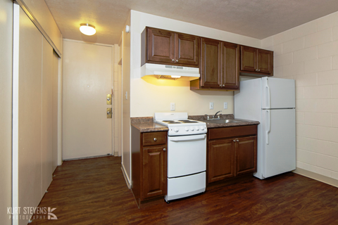 a kitchen with white appliances and wooden cabinets and a refrigerator