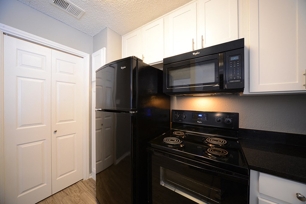 The Trellis at Lake Highlands kitchen area with refrigerator, stove, and cabinets 