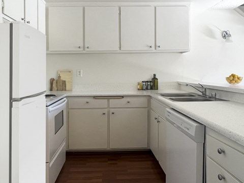 a kitchen with white cabinets and a sink and a refrigerator