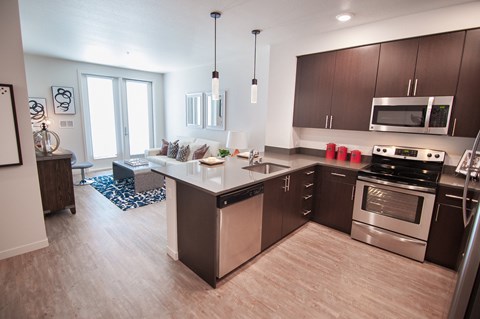 A modern kitchen with a large island and stainless steel appliances.at Cadence Apartments, HAYWARD, 94544