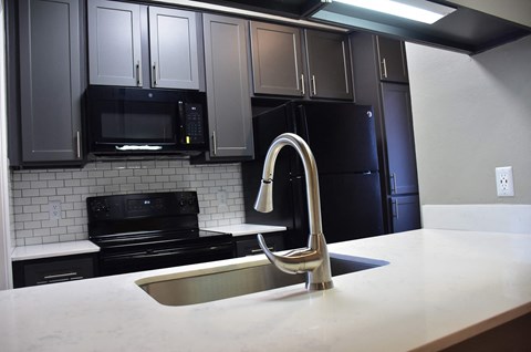a kitchen with black appliances and white counter tops