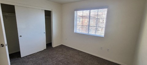 a bedroom with a window and a closet