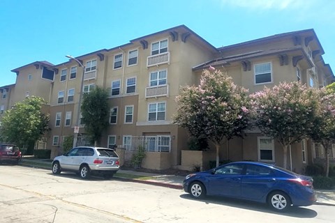 an apartment building with two cars parked in front of it