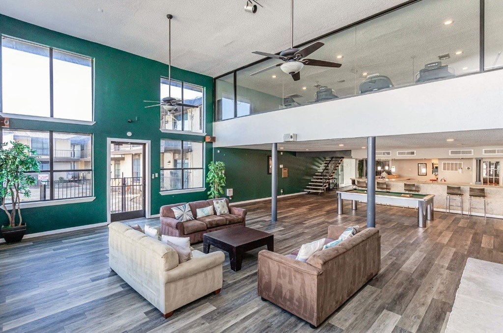 A living room with a green wall and a ceiling fan.