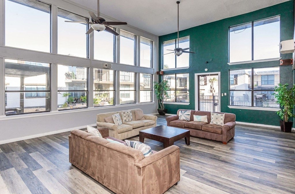 A living room with a large window and a ceiling fan.