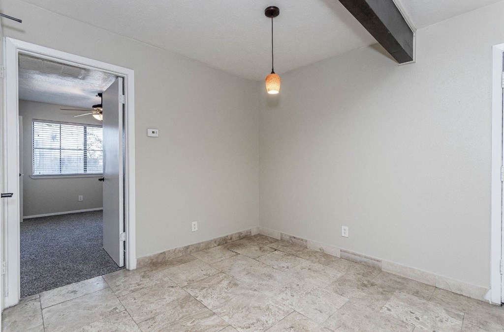 A room with a ceiling fan and a light hanging from the ceiling.