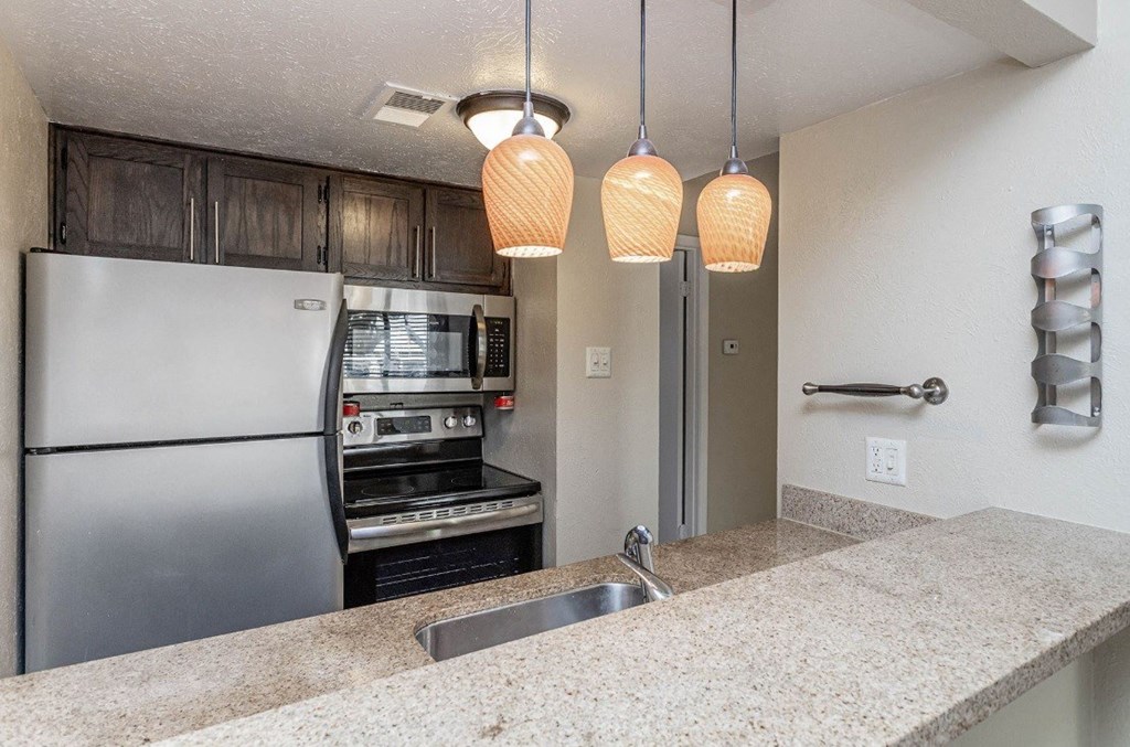 A kitchen with a stainless steel refrigerator and a built-in oven.