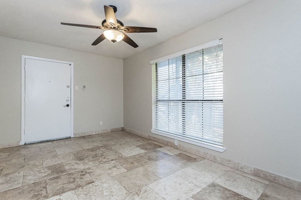 A room with a ceiling fan and a door.