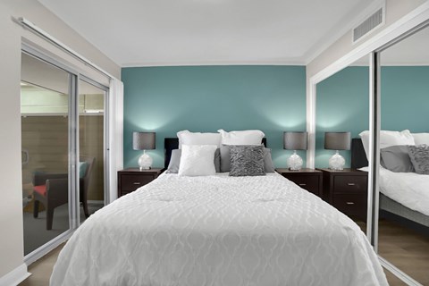 A bedroom with a large bed and two nightstands with lamps.