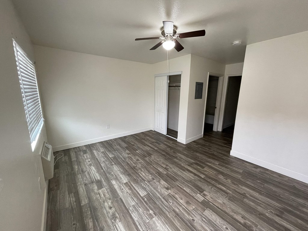 an empty living room with a ceiling fan