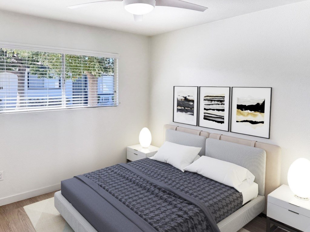 A bedroom with a bed, nightstands, and pictures on the wall.