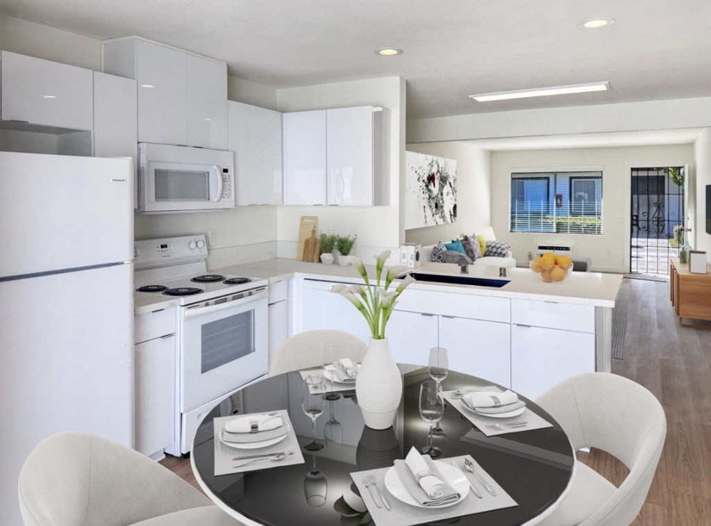 A modern kitchen with a dining table set for two.