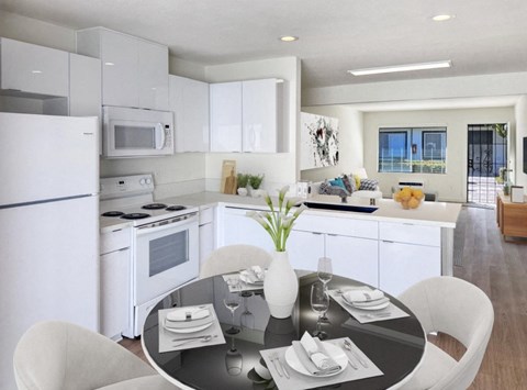 A modern kitchen with a dining table set for two.