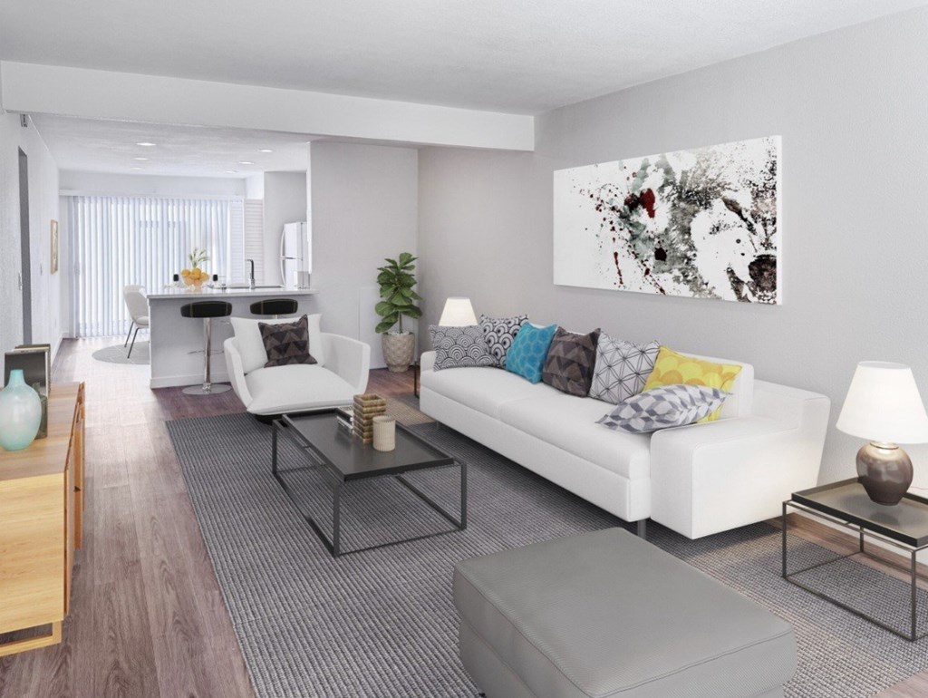 A modern living room with a white couch, a coffee table, and a large abstract painting on the wall.