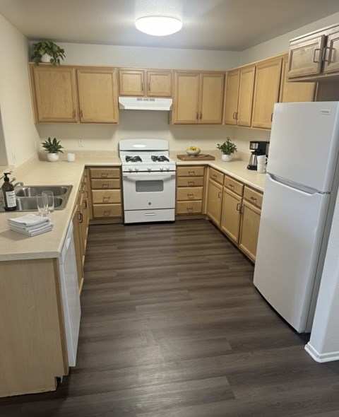 A kitchen with wooden cabinets and a white fridge.