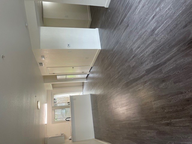 A hallway with a wooden wall and a white door.