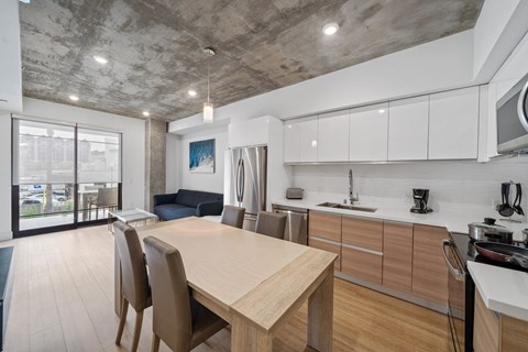 A modern kitchen with a dining table and chairs.