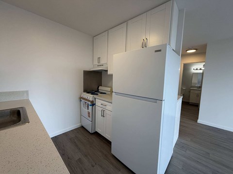 McCully Circle unit 303 kitchen with white cabinets and appliances.