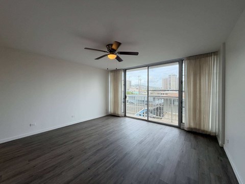 McCully Circle unit 303 living room with a ceiling fan and sliding glass doors.