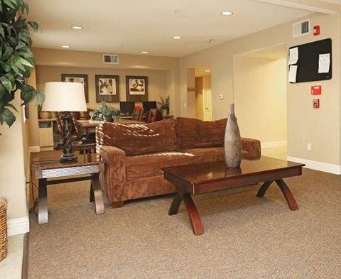 A living room with a brown couch and a coffee table.