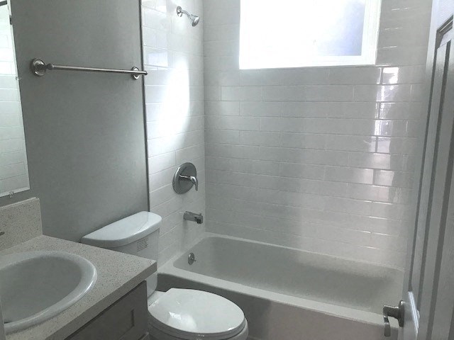 Millennium Apartments bathroom with sink, shower, and toilet